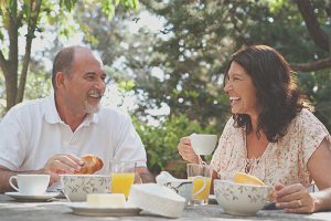 middle-aged couple smiling while sharing a meal