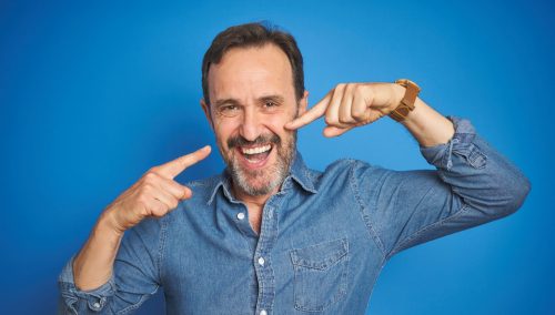 Man pointing at his smile with both hands